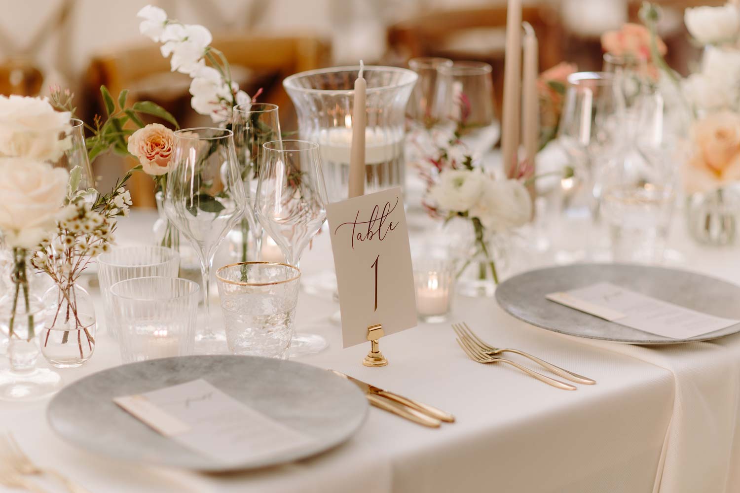 Table 1 – laid with golden cutlery, artisan crockery and a damask tablecloth
