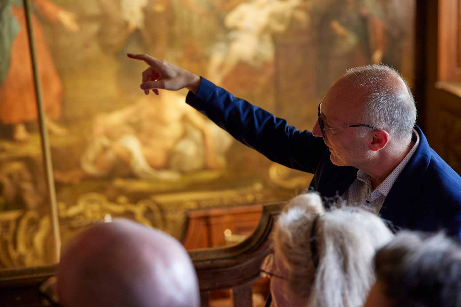 An expert points out details on one of the Hogarth paintings to a party of visitors