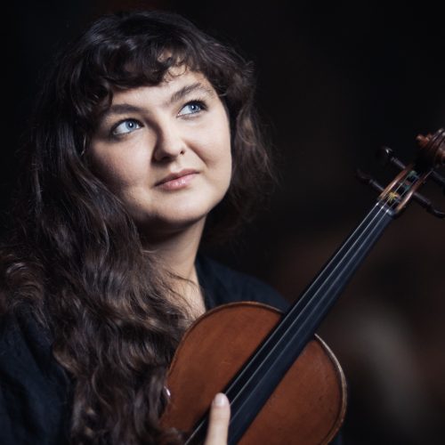 Woman holding a musical instrument.
