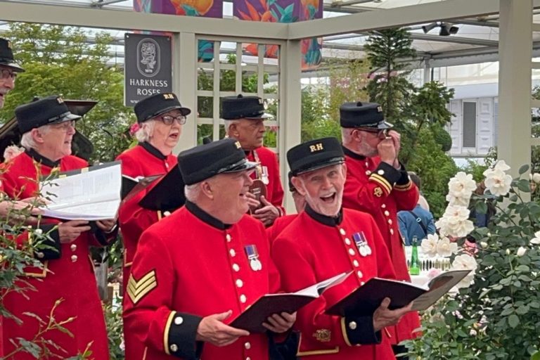 Group of Chelsea Pensioners singing.