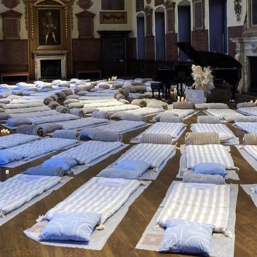 Mattresses laid out in a crescent shape with a piano at the top of the crescent.